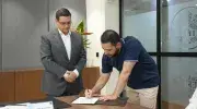 Carlos Andrés Castro Galvis, director de la Especialización en Medicina de Urgencias realizando la firma del acta de su posesión, a su izquierda Pablo Rubén Vernaza Gómez, secretario general de la Seccional. 